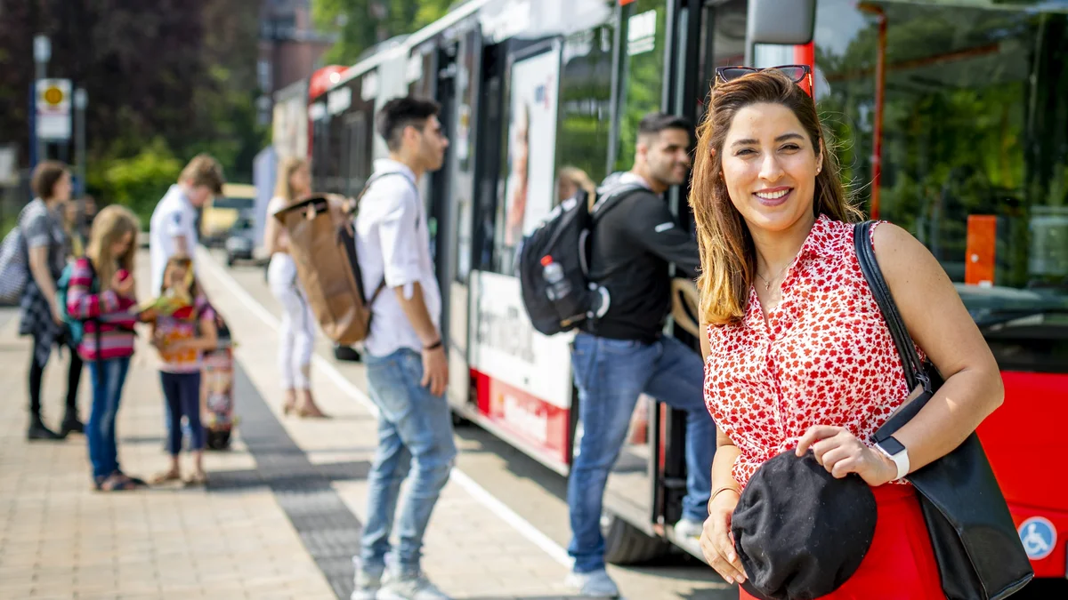 Junge Frau steht vor Bus